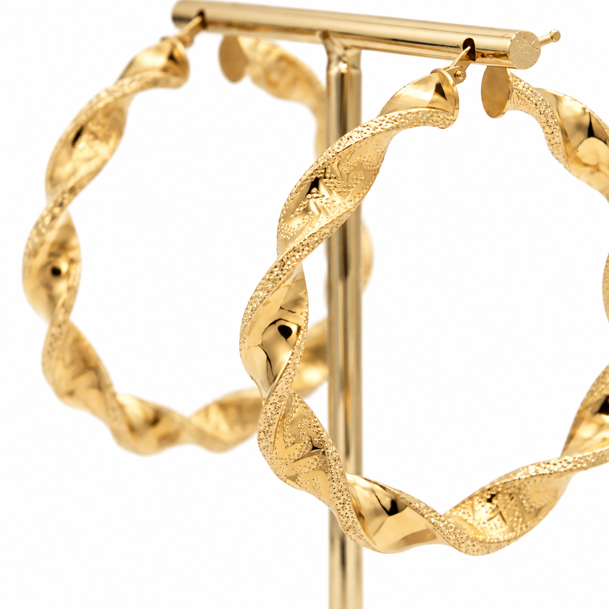 "Coppia di orecchini a cerchio torcion in oro giallo 18kt 750 con lavorazione a greca diamantata diametro 50mm e spessore 6mm su espositore, Gilma Gioielleria."